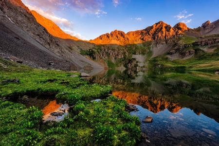 Clear lake sunrise - nice, sky, colorful, clear, mirrored, rocks, crystal, amazing, mountainscape, reflection, clouds, grass, cliffs, lake, mountain, shore, lovely, peaks, glow, beautiful, stones, sunrise