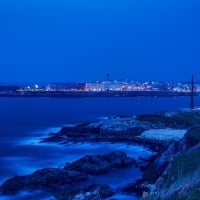 entering a harbor of a spanish city at night