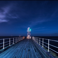 beacon at end of a pier at night