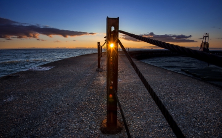 sunset through a metal post on a pier - pier, chain, sunset, posts, sea