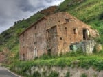 abandoned stone house by a mountain road