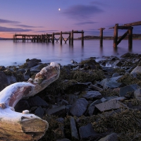 broken pier on a scottish river mouth at night