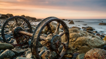 old train wheels stranded on a rocky shore - train, wheels, shore, sea, rocks