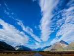 long highway through a valley under big skies