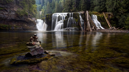 rock tower in front of a gorgeous waterfall - formation, forest, pool, rocks, waterfalls