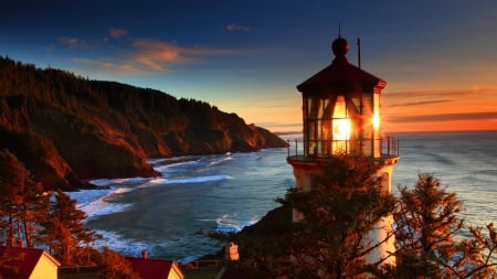 glowing lighthouse on a red oregon sea coast - autumn, lighthouses, sky, popular, water, sunset, coast, oceans, architecture, lighthouse, mountain, light, night, wallpaper, glow, costal, red, sea