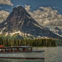 sinopah mountain and tour boat on glacier lake hdr