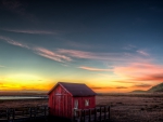 red cabin in wetlands at sunset