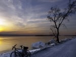 bicycle on a pebble road along a bay at sunset