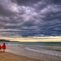 women walking on a windy beach in spain