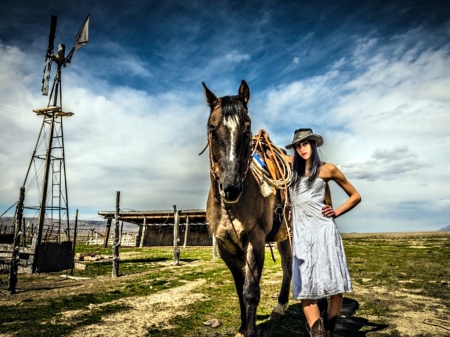 Cowgirl - pretty, leather, grass, western, Cowgirls, famous, houses, sky, women, fences, beautiful, guns, models, rodeo, outdoors, horses, ranch, winmills