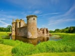 a pond around a beautiful castle ruins