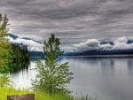 cloud covered mountains by a lake