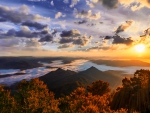 sunset over cloud covered mountain range