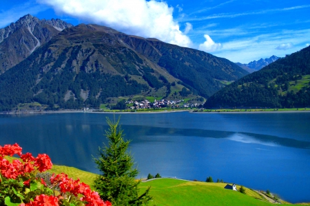 Lago di Resia - lakeshore, sky, water, greenery, clear, mirrored, vacation, view, reflection, clouds, grass, lake, hills, landscape, mountain, summer, lovely, village, blue, beautiful, lago, rest, flowers