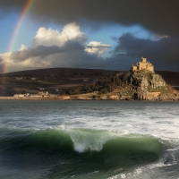 rainbow over a castle on a seaside hill