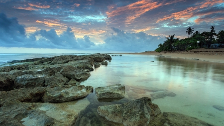 rocky wave breaker along a tropical beach - beach, clouds, palms, sea, rocks, wave breaker