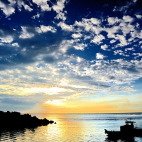 boat returning to harbor in a beautiful sunset