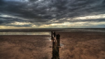 line of old wooden pillars on a beach hdr - wood, beach, clouds, pillars, hdr, sea