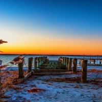 partial pier on a beach at sunrise