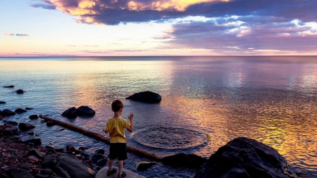 boy throwing stones in the sea - ripples, boy, clouds, shore, sea, rocks