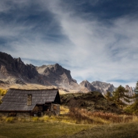 mountains above a cabin in a meadow