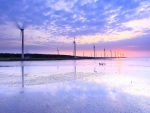 spinning windmill turbines in a lavender sunrise