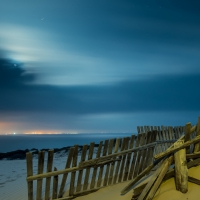 broken fence on a beach at night