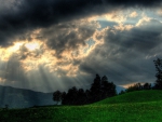 sunbeams over green hills