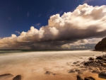 stars above heavy clouds over seashore