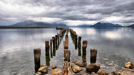 pillars on a bay in patagonia in chile - pillars, clouds, gray, mountains, bay