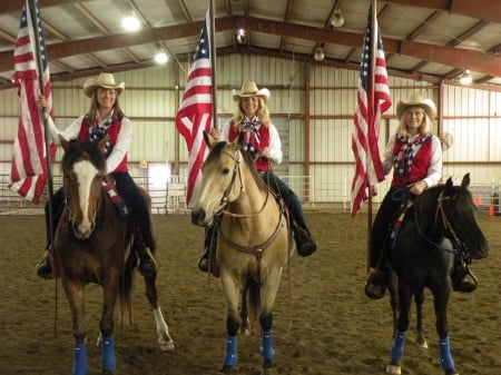 Patriotic Cowgirls - building, fence, american flags, cowgirls, hats, horses, blondes, brunette, flags