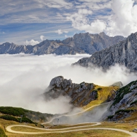 winding road down bavarian alps into sea of clouds