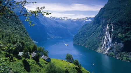 spectacular view of a norwegian fjord - ship, waterfalls, meadow, mountains, cabins, fjors