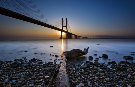 Lisbon Sunrise... - river shore, morning calm, dead trunk, dawn, beautiful, river, stones, sunrise, bridge