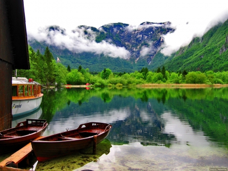 Tranquility - boat, tranquil, reflection, mountain, calmness, shore, mist, lake, emerald, sky, clouds, house, greenery, fog, beautiful, nature, green, serenity