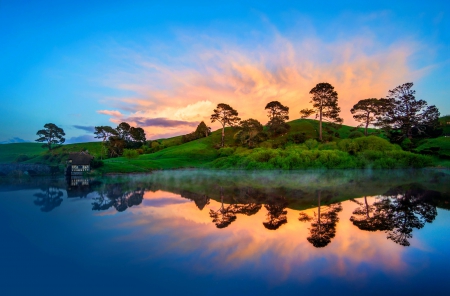 Sunrise Reflection - calm, house, trees, hills, yellow, blue, beautiful, sunrise, reflection, dawn, green, meadows, lake, sky