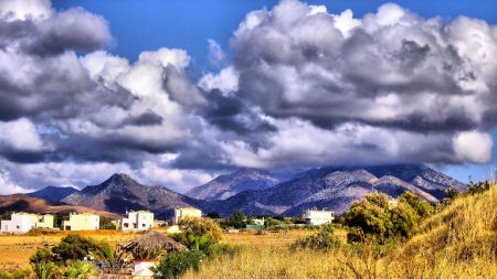 beautiful clouds over a village - village, mountains, clouds, grass