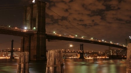 brooklyn bridge under a cloudy night