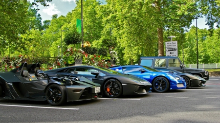 row of parked super cars - cars, trees, blacktop, parking