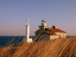 old lighthouse on a windswept grassy coast