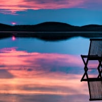 chair in a mirrored lake at sunset