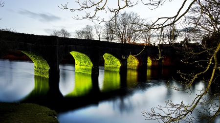 an old arch bridge at dusk - trees, reflection, river, arches, dusk, bridge, lights