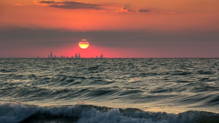 sunset over cityscape beyond the sea - sea, haze, sunset, cityscape