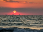 sunset over cityscape beyond the sea