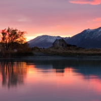 stone lake house in a pink sunrise