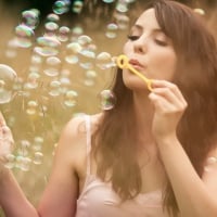 cute girl playing with soap bubbles