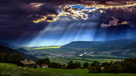 Shining Through... - sunbeams, valley, sky, houses, mountains, meadows, cityscape, huts, forest, sun light, clouds, beautiful, grass, wildflowers