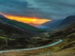 road down a scottish valley at sunset