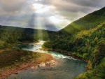 Sun Breaking through Clouds over Mountain Forest